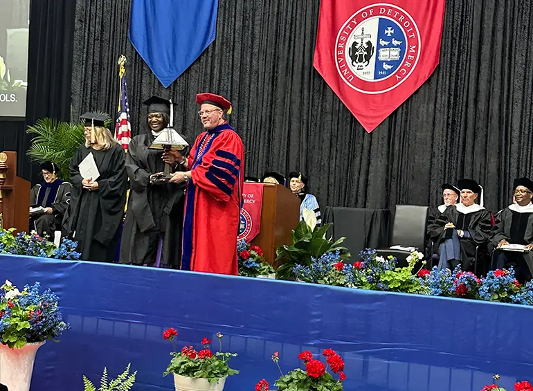 President Taylor presentin Wendy Nichols with the 2025 Vivere ex Missione Award at the 2025 Commencement Ceremony