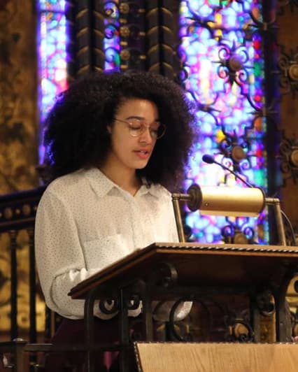 Mary Elizabeth Johnson reading her poem at podium