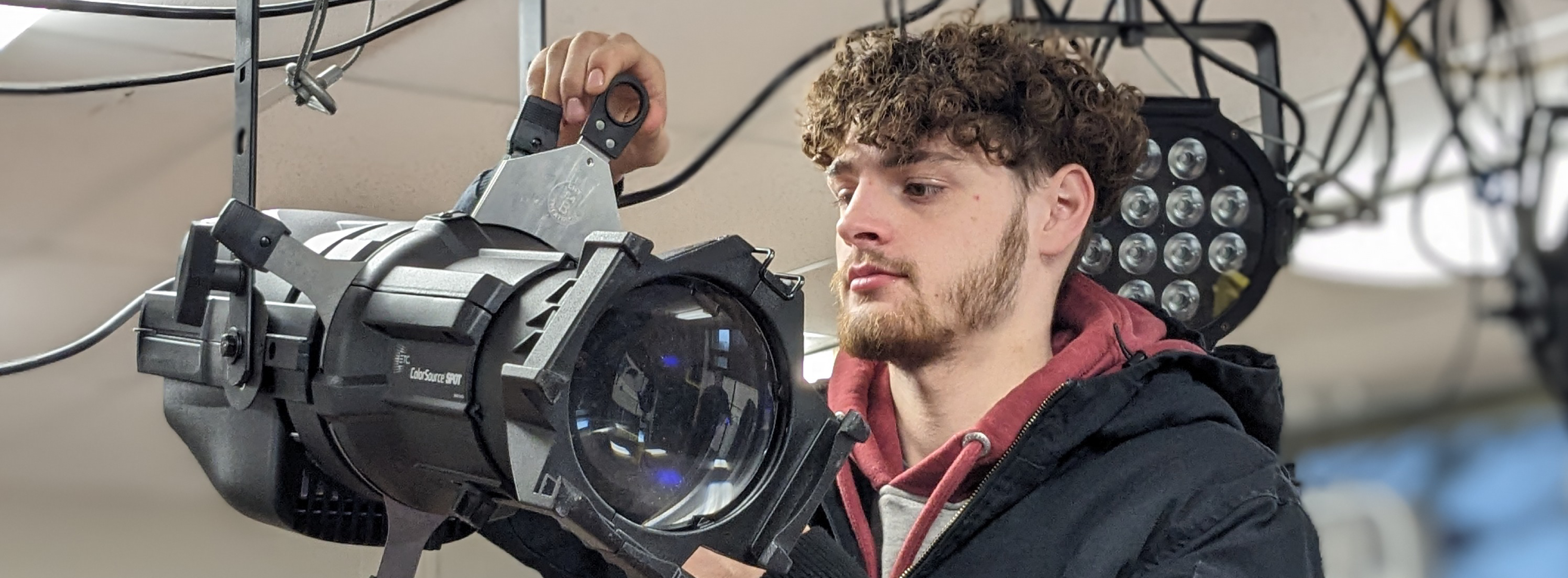 A student hangs a theatre light