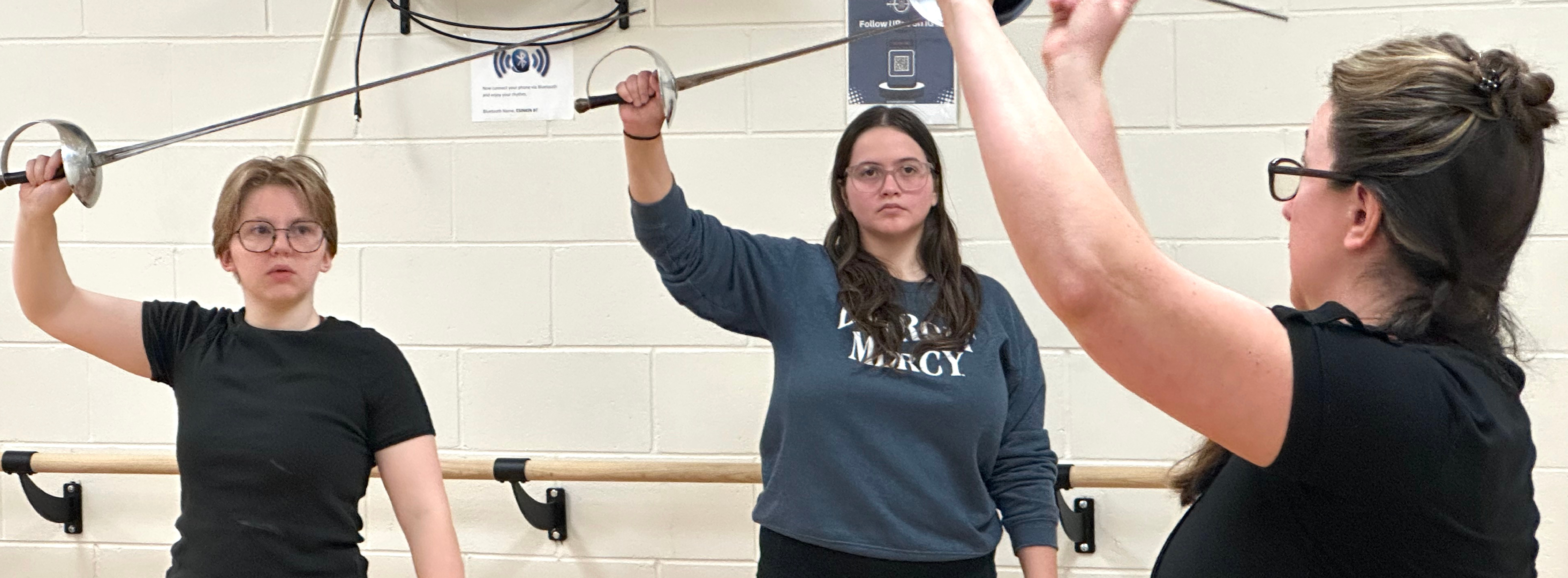 Two theatre students learn stage combat from a guest artist